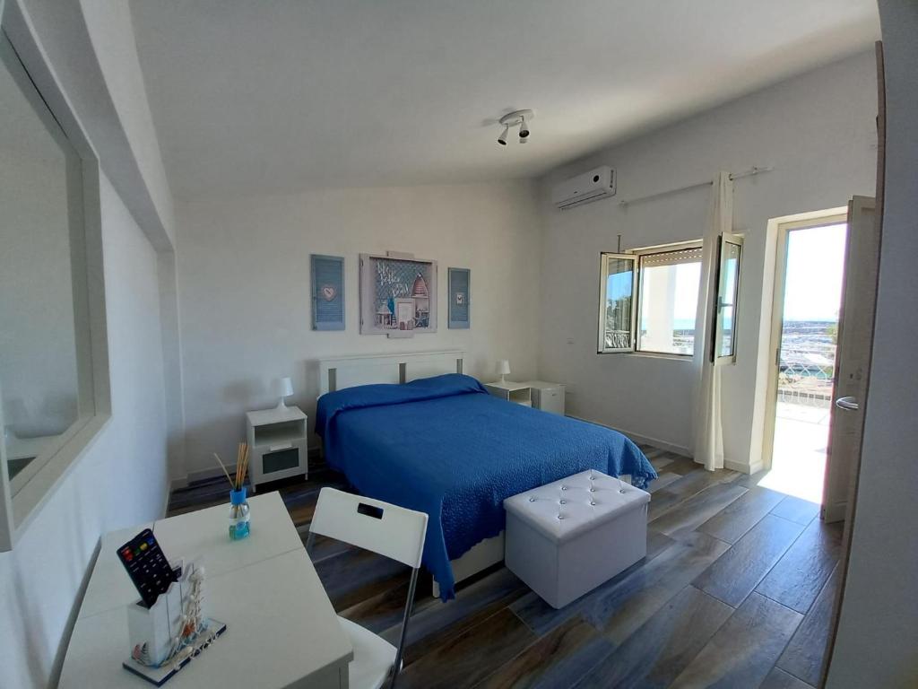 Un dormitorio con una cama azul y una mesa en Da Angelo en Borgo