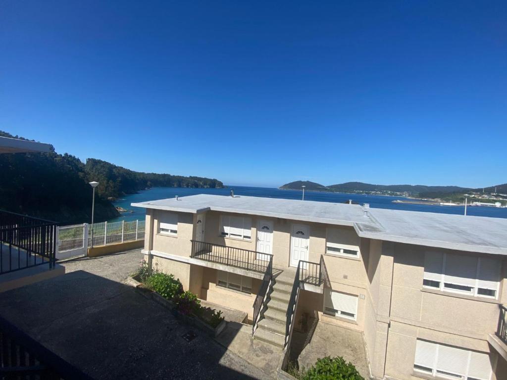 um edifício com vista para a água em Apartamentos Las Sirenas em Viveiro