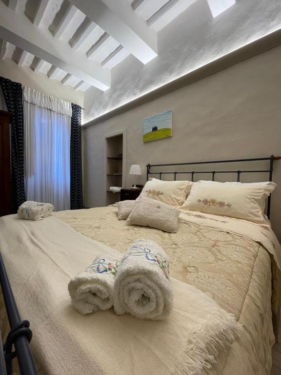 a bedroom with a large bed with towels on it at Pienzalettings in Pienza