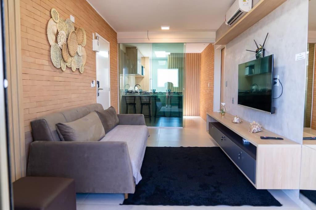 a living room with a couch and a tv at Apto 2 suites com elevador no Frances -Adm Nutelss in Praia do Frances