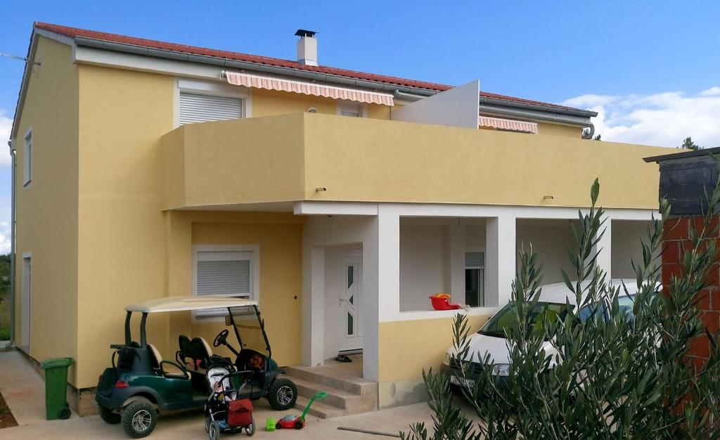ein Haus mit einem Golfwagen davor in der Unterkunft Apartments Sunset in Olib