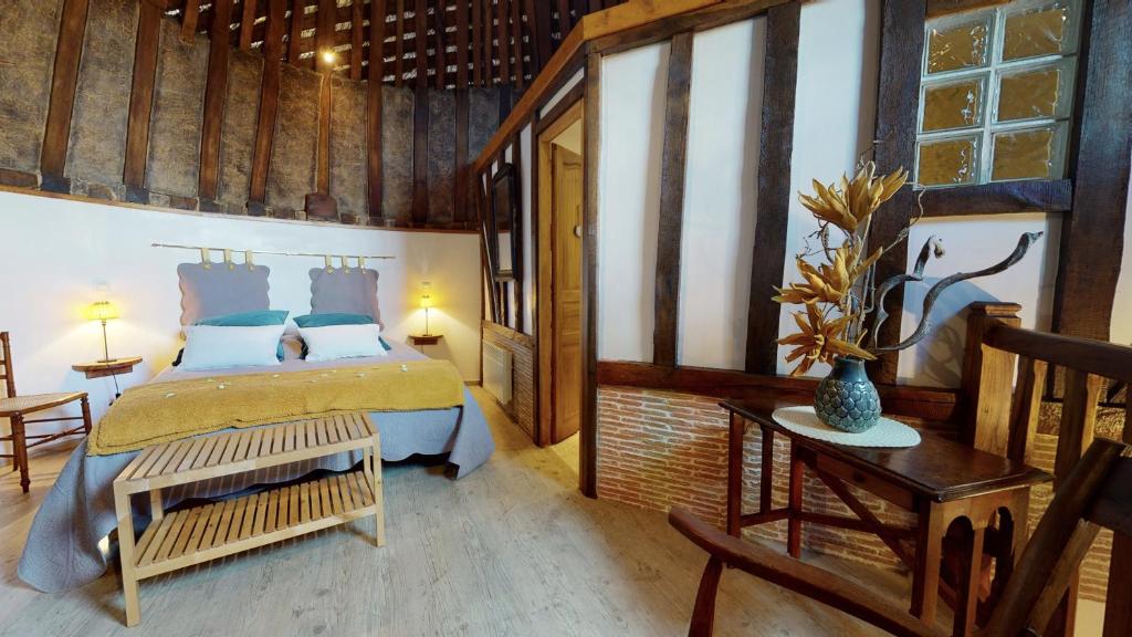 a bedroom with a bed in a room with wooden walls at Gîte Le Colombier de la Lanterne in Vannecrocq