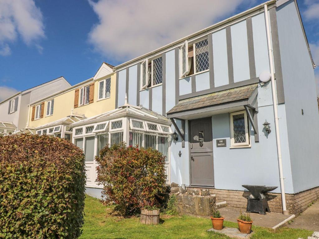 uma grande casa branca com um jardim da frente em The Smithy em Tenby