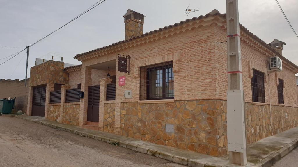 un edificio de ladrillo con una torre de reloj en una calle en Casa Julia, en Belmonte
