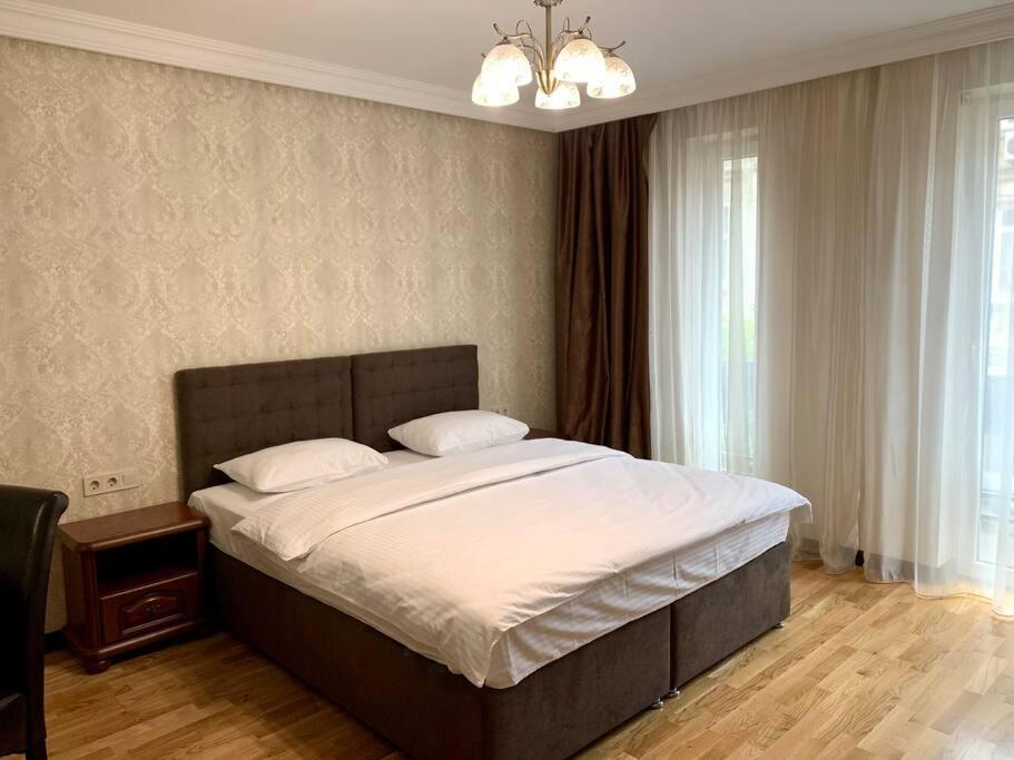 - une chambre avec un grand lit et des draps blancs dans l'établissement Апартаменти в новобудові, à Lviv