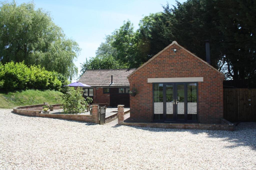 a small brick house with a gate and a fence at The Rectory Lacock Cottages in Lacock