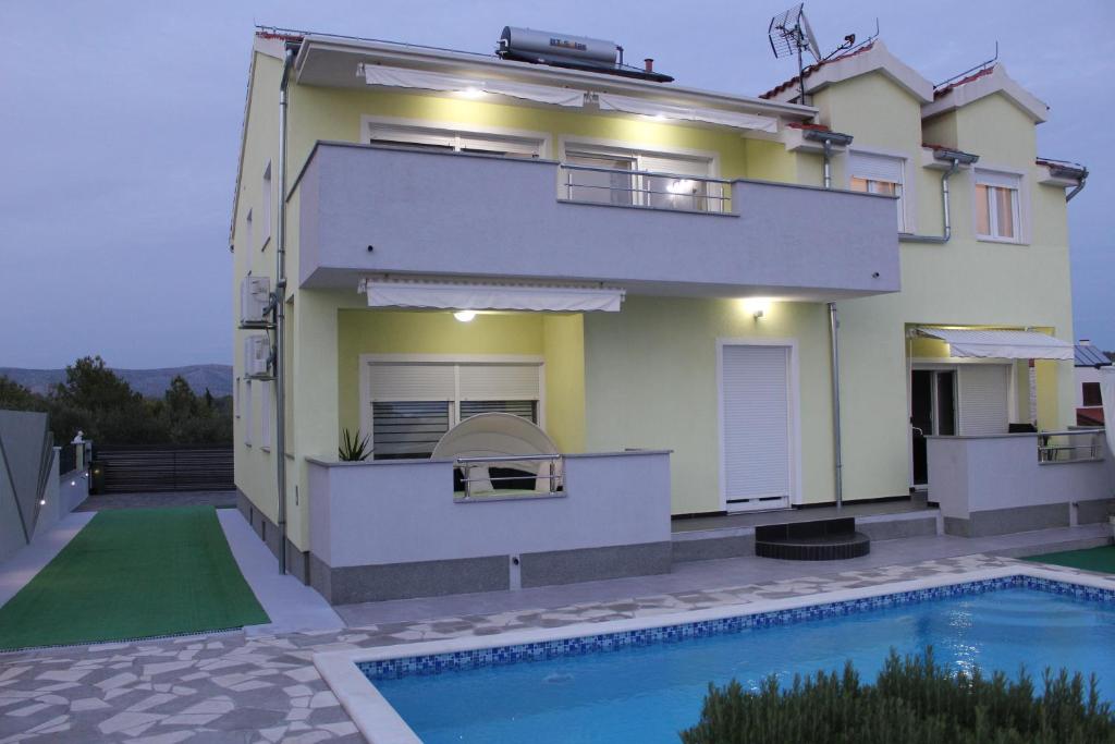 a house with a swimming pool in front of it at Holiday home Villa Anny in Brodarica