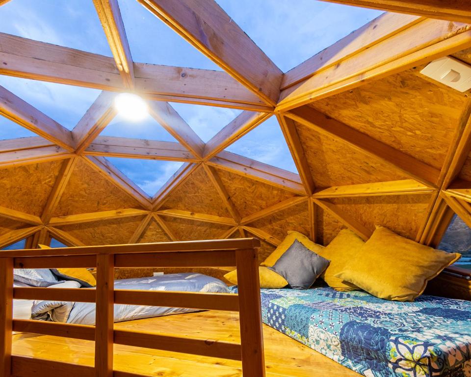 a bed in a wooden room with a roof at Los Nopales Glamping in Sáchica