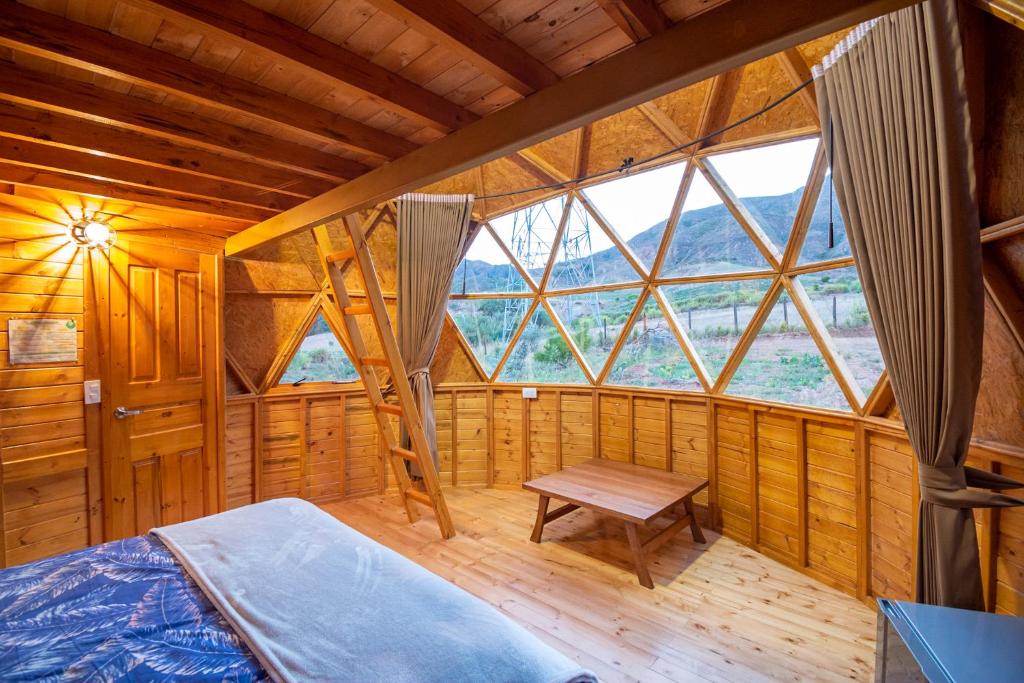 a large room with a bed and a window at Los Nopales Glamping in Sáchica