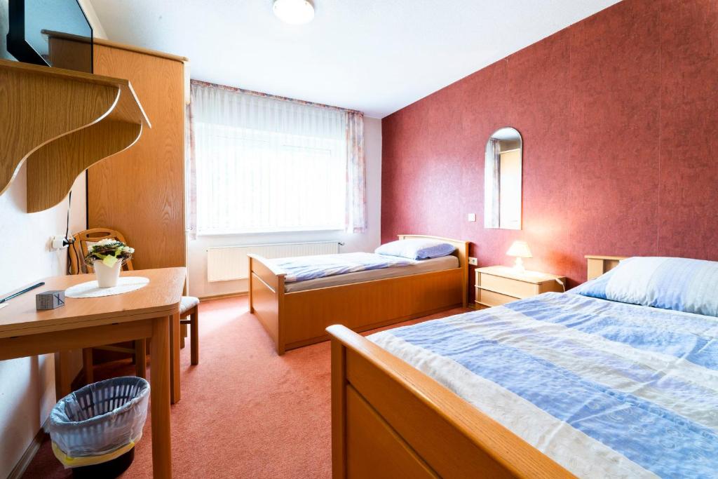 a hotel room with two beds and a desk at Gästezimmer 5 im Landgasthaus Lindenhof in Fresenburg