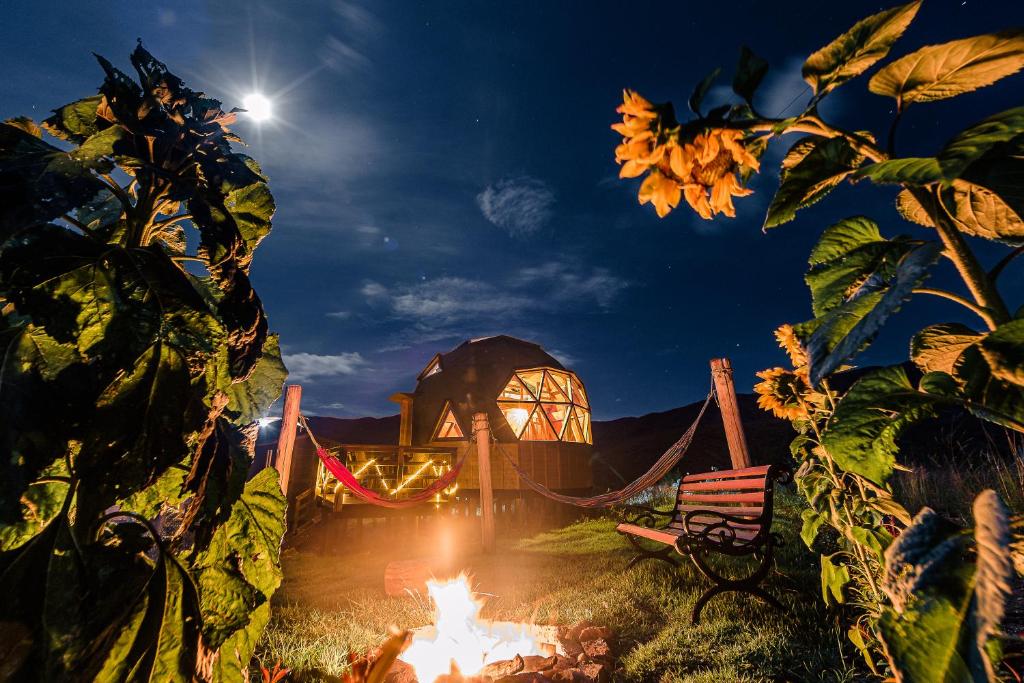 a campfire in front of a building at night at Los Nopales Glamping in Sáchica