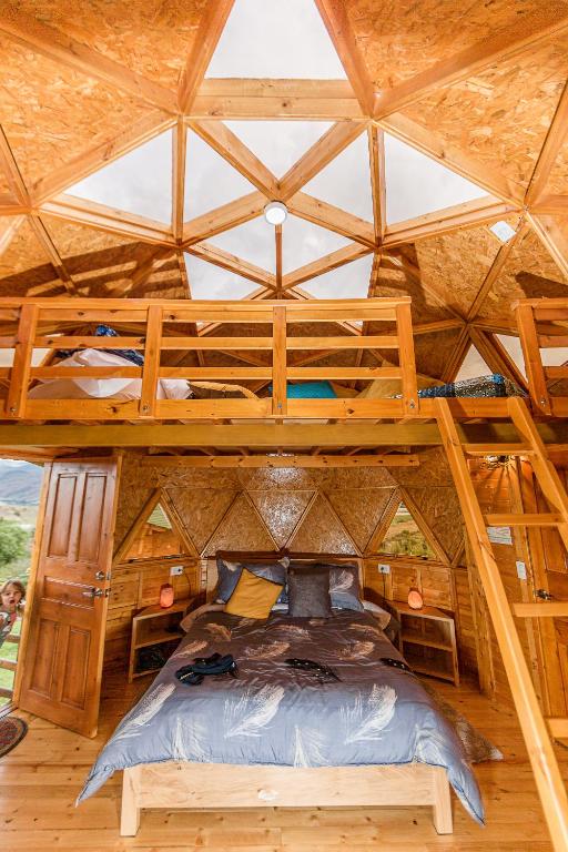 a bedroom with a bunk bed in a wooden cabin at Los Nopales Glamping in Sáchica