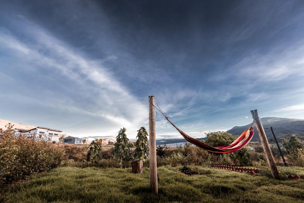 a hammock on a pole in a field at Los Nopales Glamping in Sáchica
