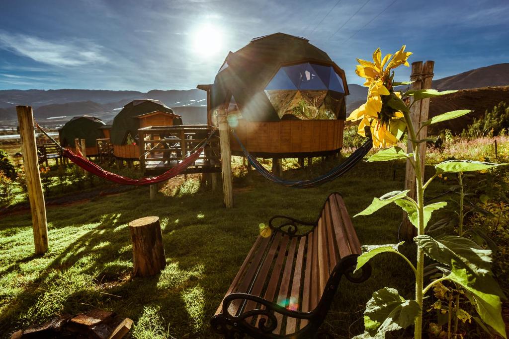 a park with a bench and a gazebo at Los Nopales Glamping in Sáchica