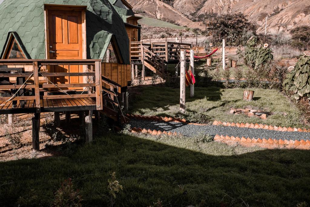 a house with a wooden door and a yard at Los Nopales Glamping in Sáchica