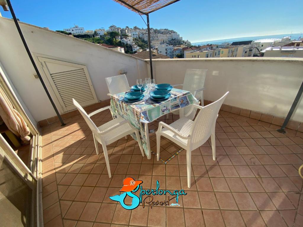 een tafel en stoelen op een balkon met uitzicht bij Casa Linda Sperlongaresort in Sperlonga