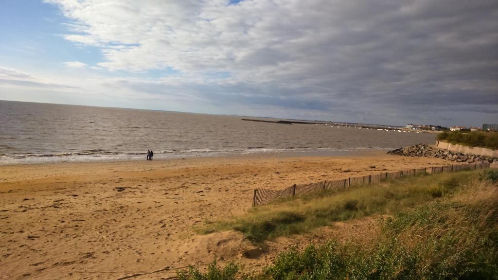 a person standing on a beach near the water at les pieds dans l'eau in Les Boucholeurs