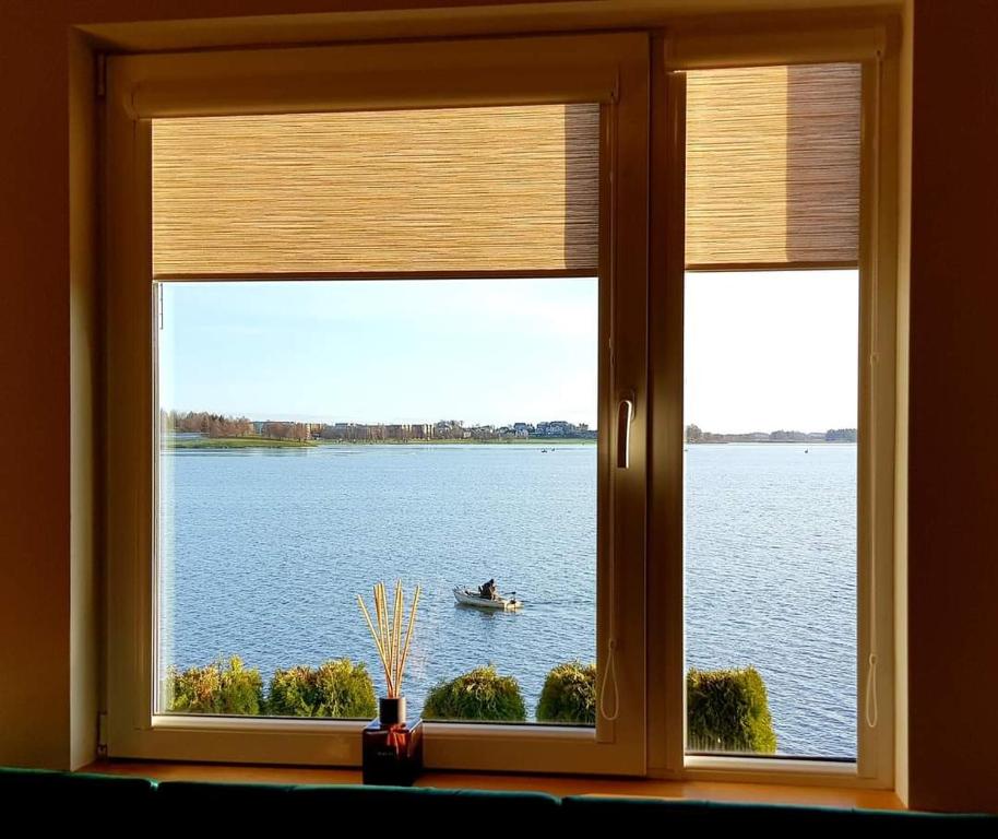 una ventana con vistas a un barco en el agua en Old Town Apartment, en Telšiai