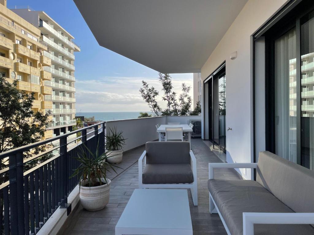 - un balcon avec un canapé et une table dans l'établissement Apartamentos Bellevue Praia da Rocha, à Portimão