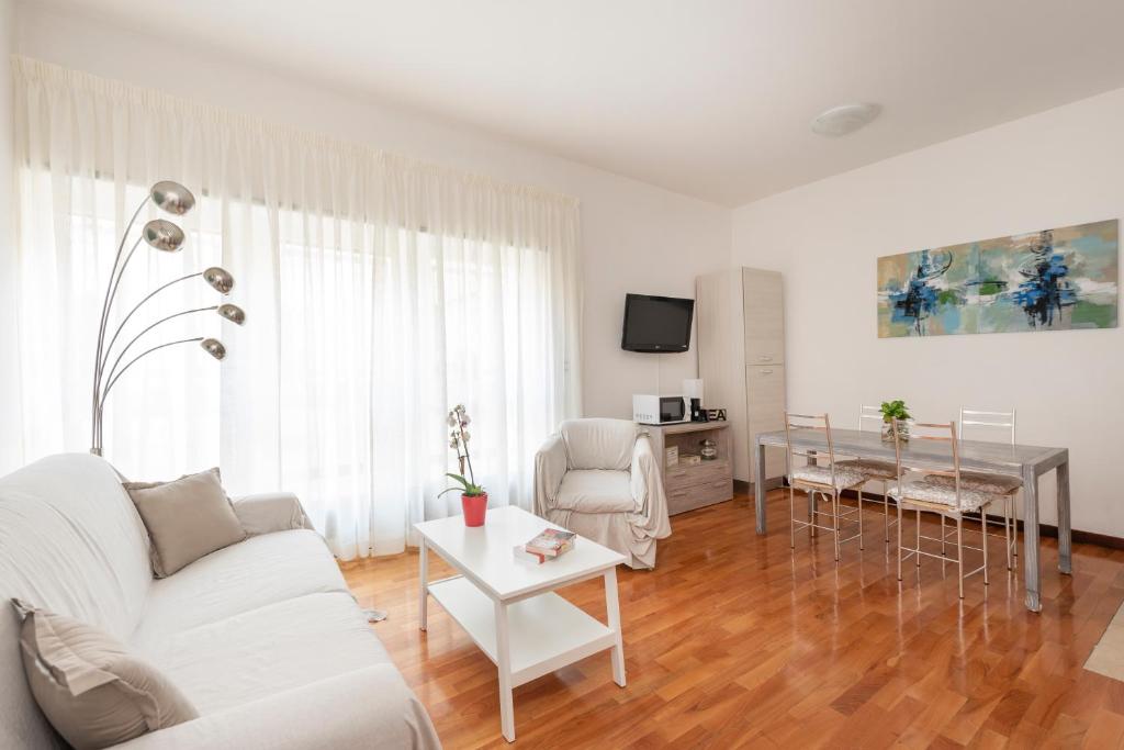 een woonkamer met een witte bank en een tafel bij Hermes Suite in Rome