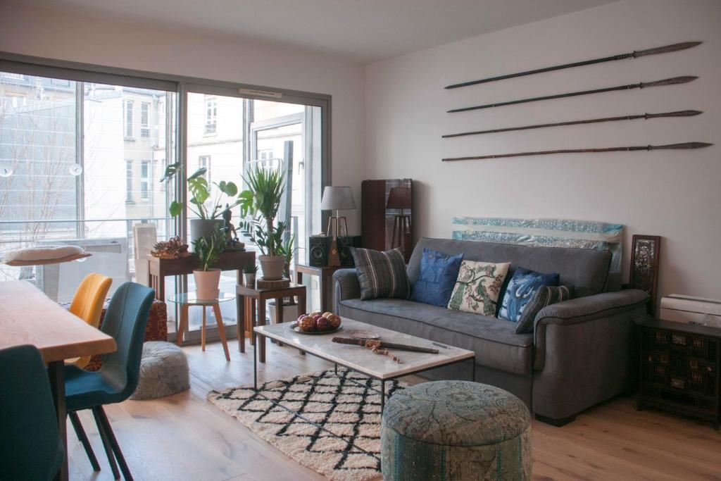 un salon avec un canapé et une table dans l'établissement Nice Apt With Balcony Near Centquatre Paris, à Paris
