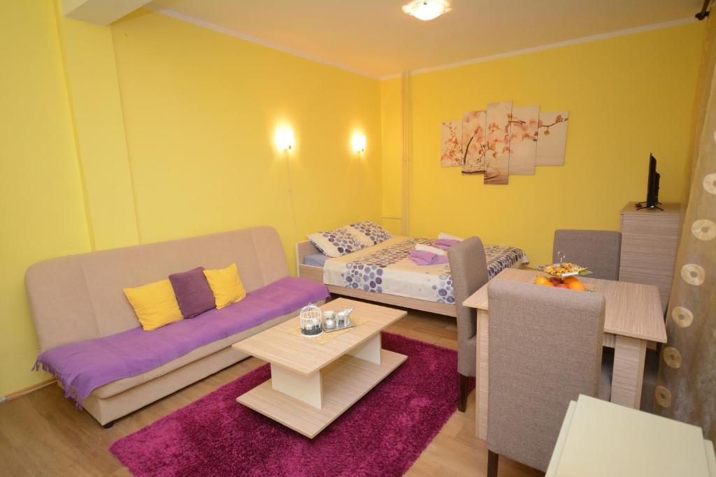 Zimmer mit 2 Betten, einem Sofa und einem Tisch in der Unterkunft Apartman Sladja in Vrnjačka Banja
