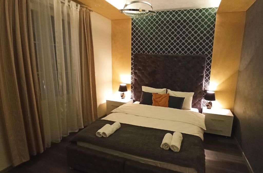 1 dormitorio con 1 cama con 2 toallas en Apartmani President III, en Banja Luka