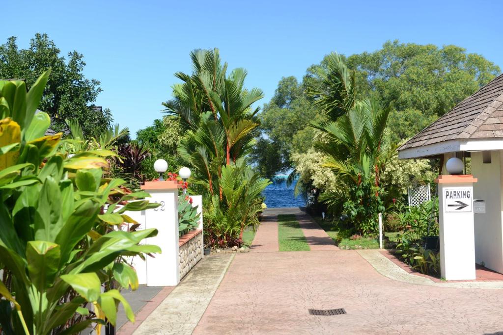 a walkway through a resort with a body of water at Pension de famille HITI MOANA VILLA in Papara