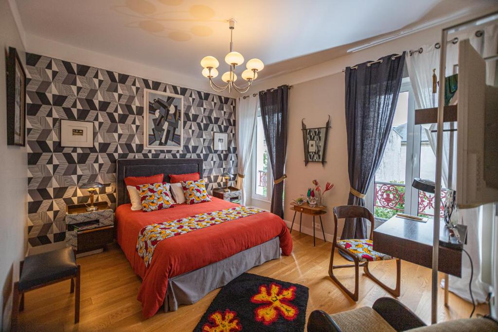 a bedroom with a red bed with a red blanket at Le Jardin des Toiles in Triel-sur-Seine