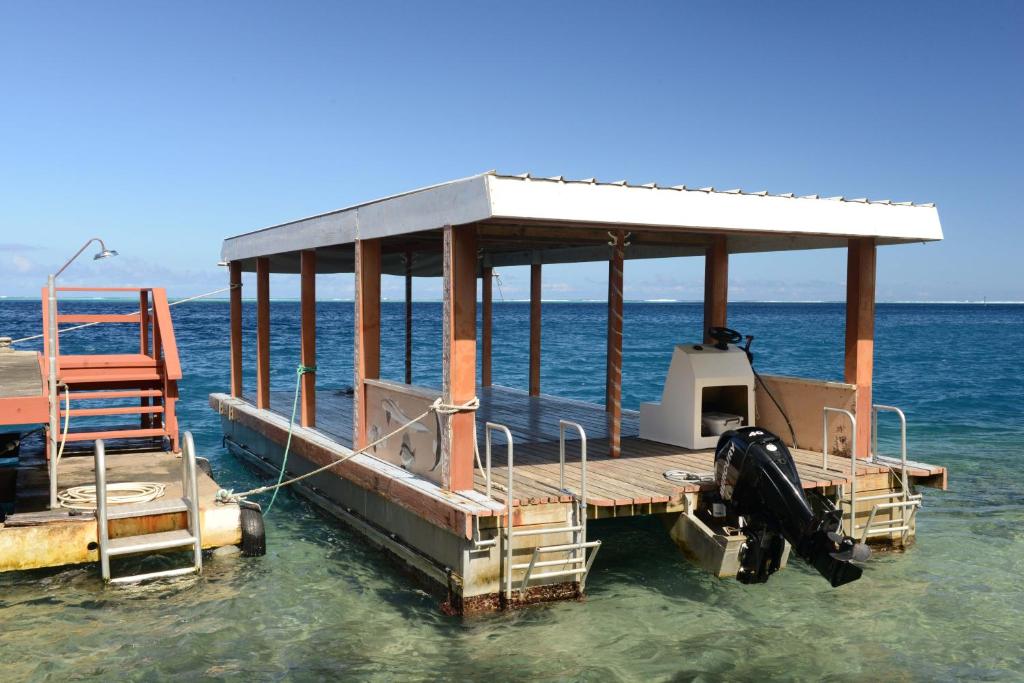a boat in the water with a chair on it at Pension de famille HITI MOANA VILLA in Papara