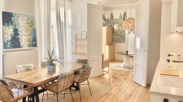 a living room with a wooden table and chairs at l'Appartement Grand Théatre in Bordeaux