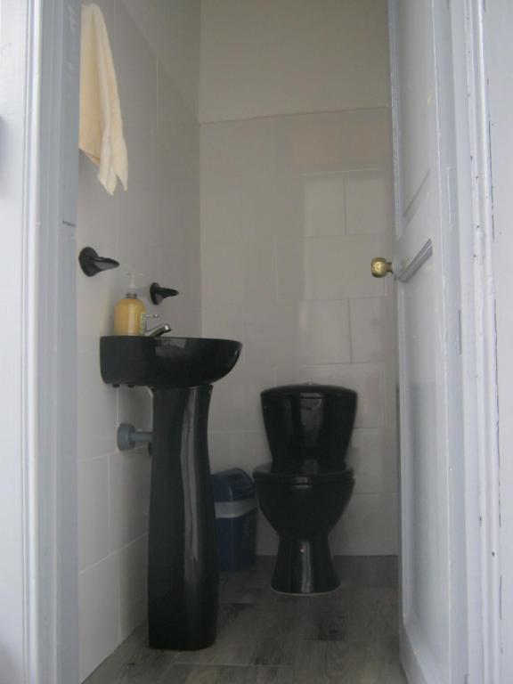 bagno con servizi igienici neri e lavandino di ANGIE`s HOUSE a Manizales