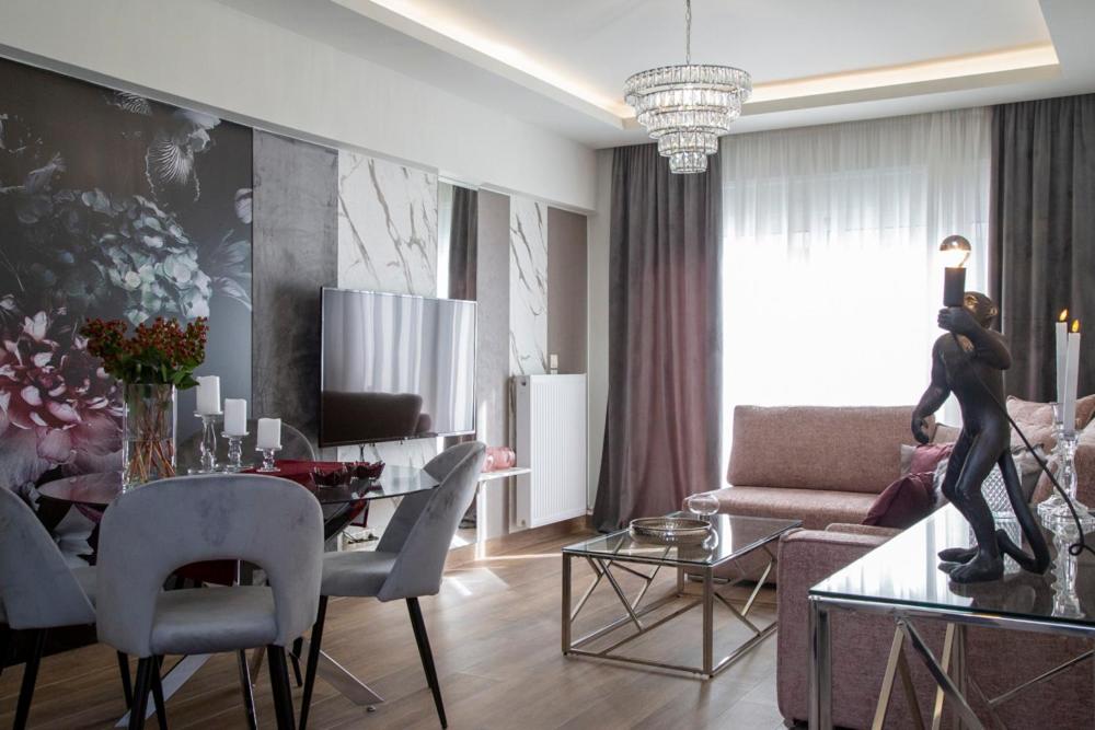 un salon avec une table à manger et un salon avec un canapé dans l'établissement Deka luxury apartment, à Tríkala
