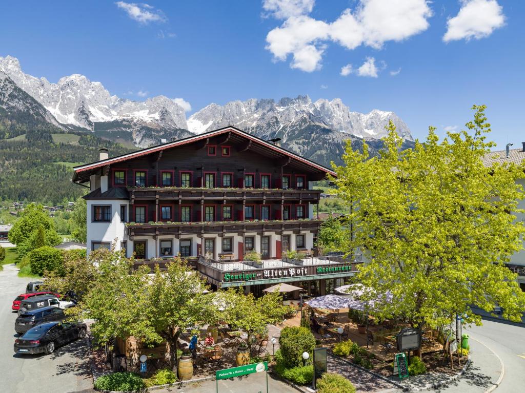 un gran edificio con montañas en el fondo en Alte Post en Ellmau