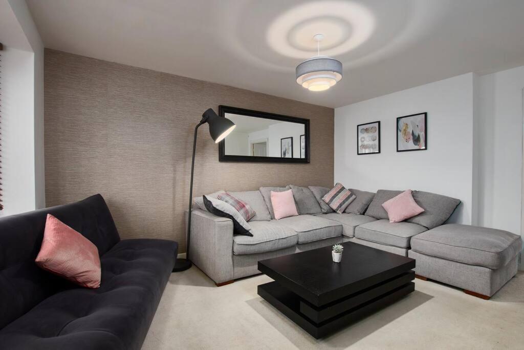 a living room with a couch and a table at Elegant 4 Bedroom House - Parking - Garden in Manchester