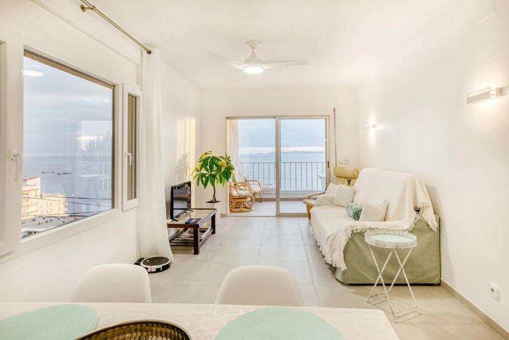 a living room with a couch and a large window at Apartament Roses Vista Mar in Roses
