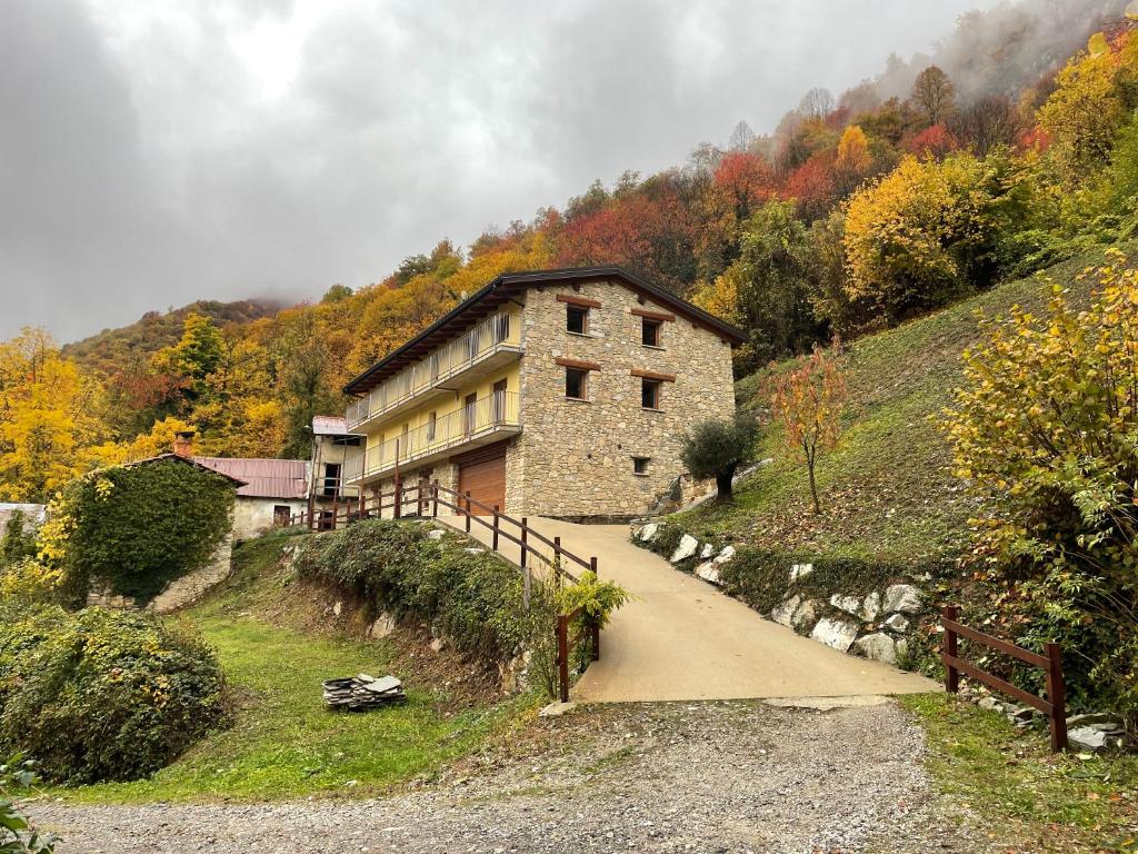 un grand bâtiment en pierre sur une colline avec un chemin dans l'établissement Affittacamere Ca' d' Giuanot, à Miroglio