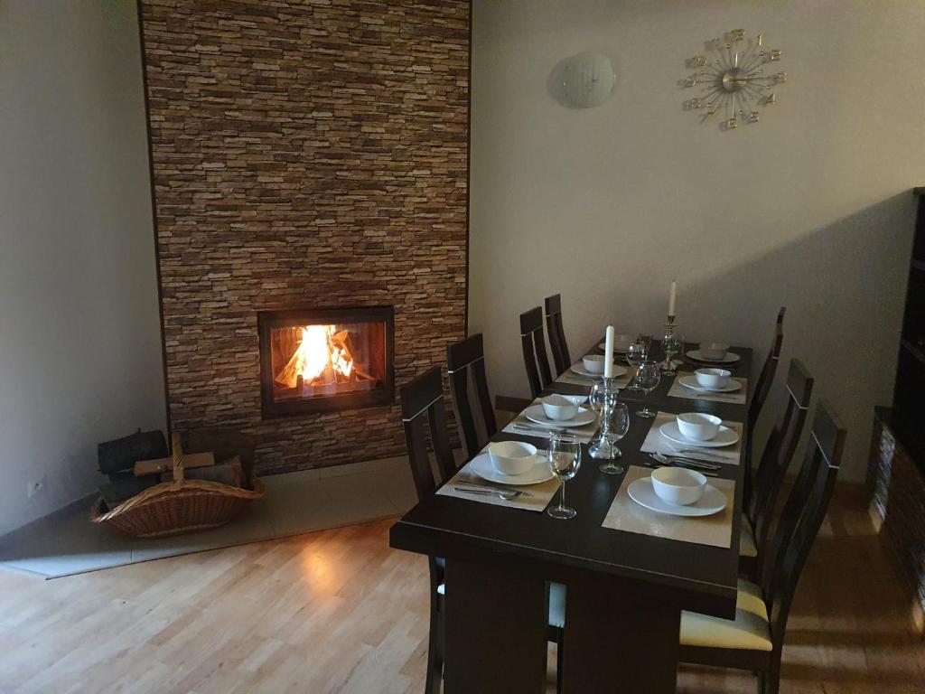 a dining room with a table and a fireplace at Vila Almini Drienica Lysa in Sabinov