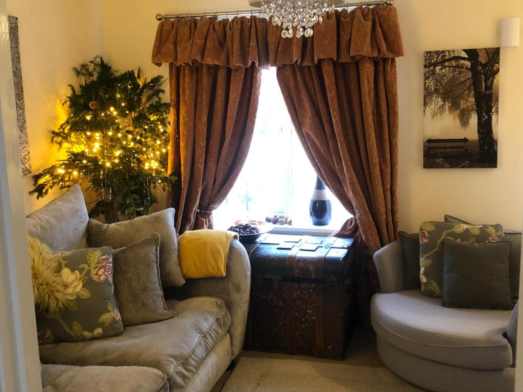 ein Wohnzimmer mit Sofa und Weihnachtsbaum in der Unterkunft Lazy Nest is a Lazy comfortable Nest to laze in Oakham