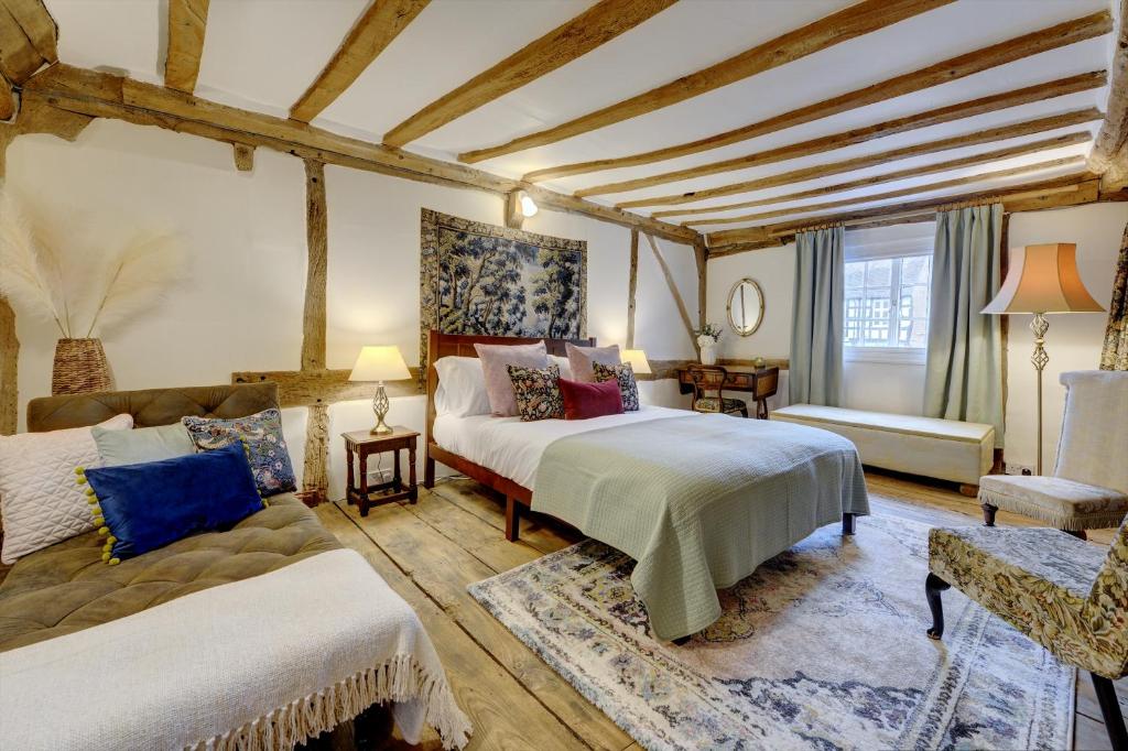 um quarto amplo com 2 camas e um sofá em Tudor Cottage by Spa Town Property - Historic Charm in Warwick Town Centre em Warwick