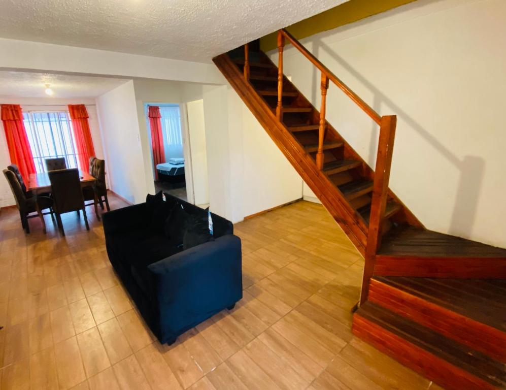 uma sala de estar com uma escada e um repousa-pés azul em Casa y departamentos amoblados Talca em Talca