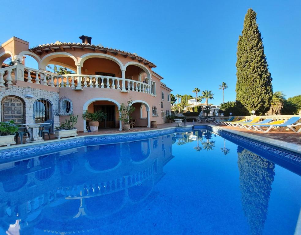 a large house with a swimming pool in front of it at Casa Cachito in Benissa