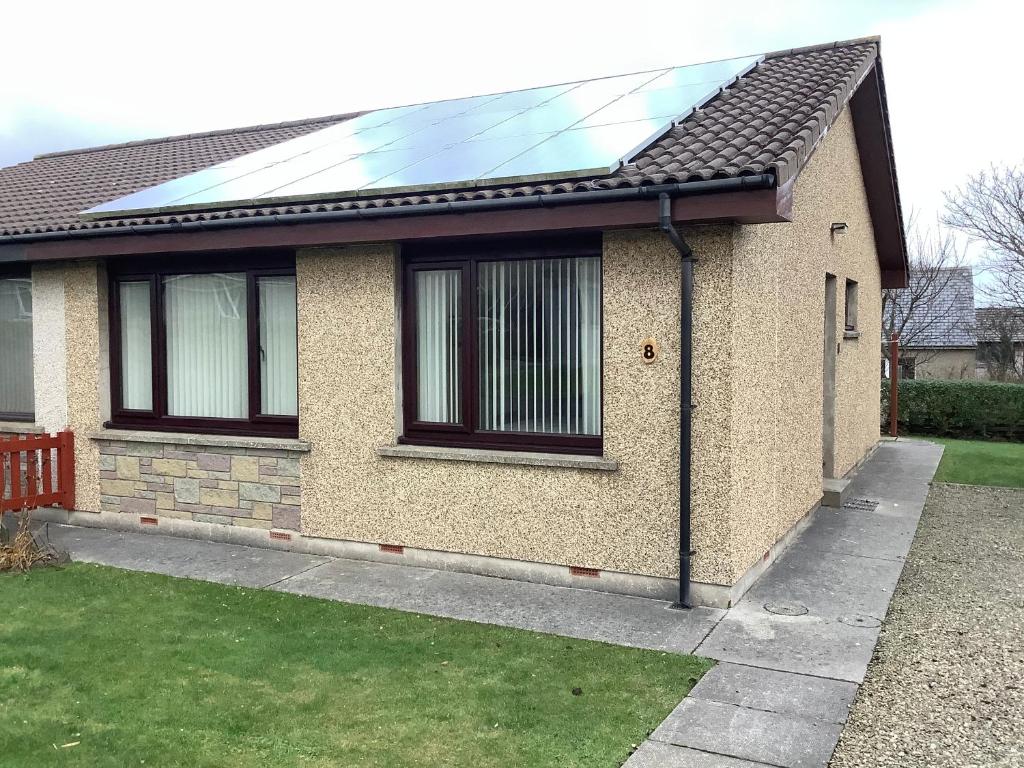 une maison avec un panneau solaire sur le toit dans l'établissement 8 Jib Park, Finstown, à Finstown