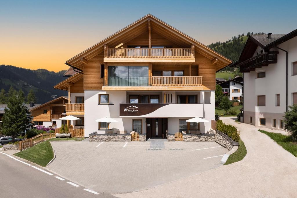 an apartment building with a large parking lot at Apartments Chalet Maria in Badia