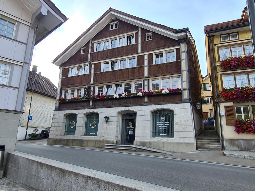 ein Gebäude mit Blumenkästen an der Straßenseite in der Unterkunft Backpacker Bären in Urnäsch