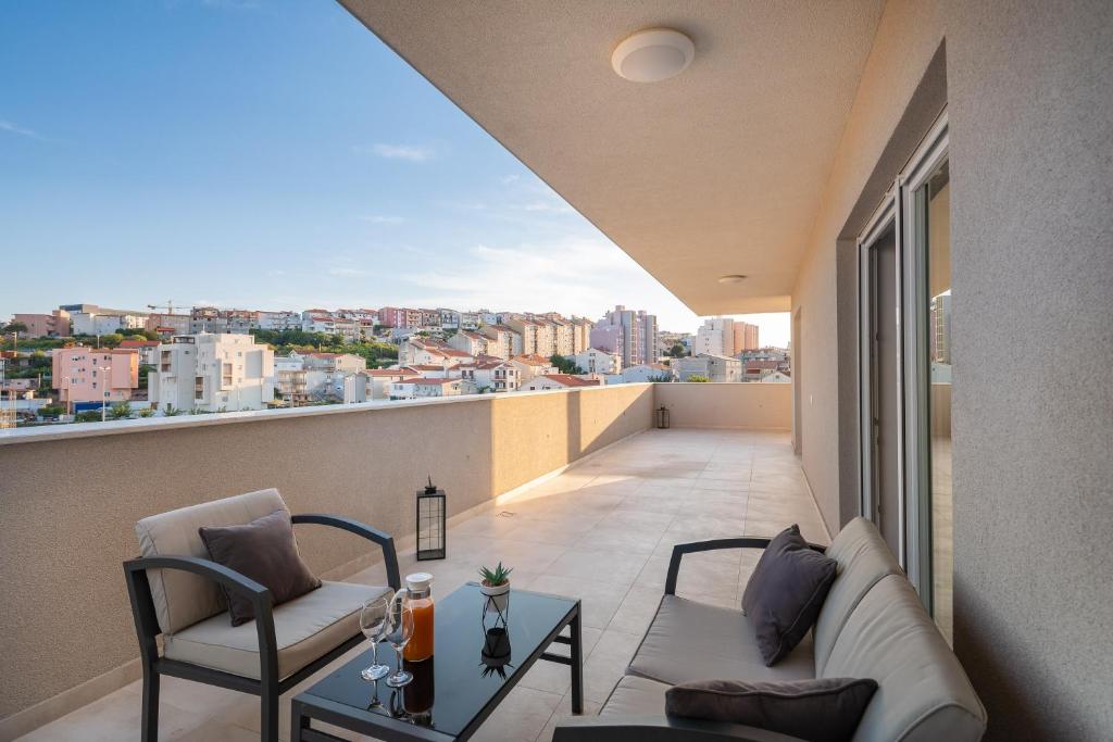 een woonkamer met een bank en stoelen op een balkon bij Luxury penthouse Papic in Split