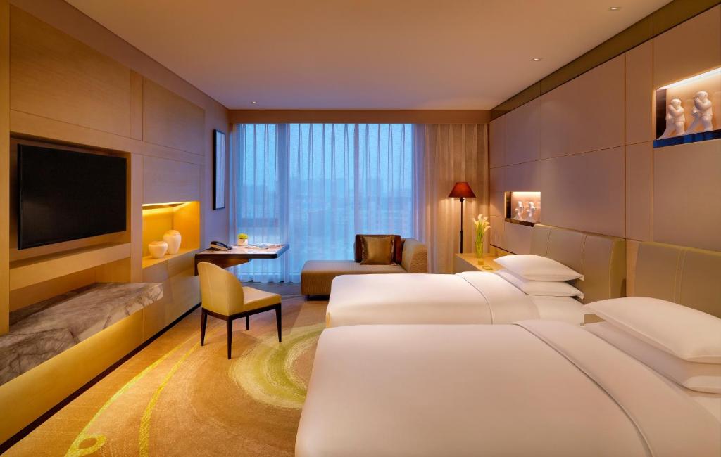 Postel nebo postele na pokoji v ubytování Hyatt Regency Tianjin East