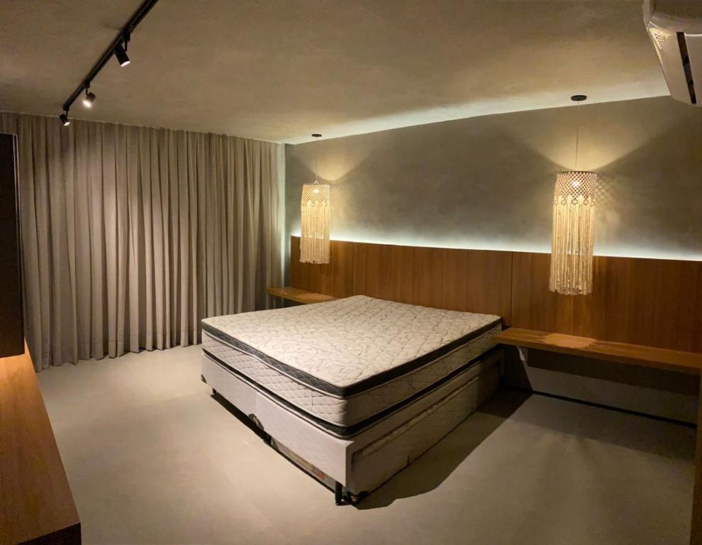 a bedroom with two beds and two chandeliers at Casa Encanto dos Milagres in São Miguel dos Milagres