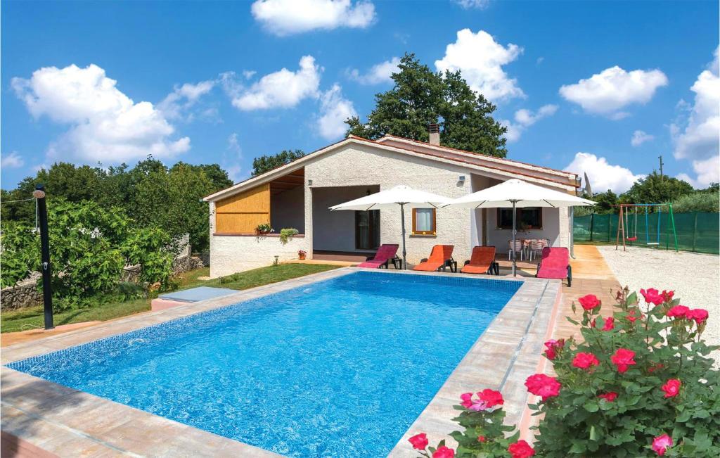 a villa with a swimming pool in front of a house at Amazing Home In Marcana With House A Panoramic View in Divšići