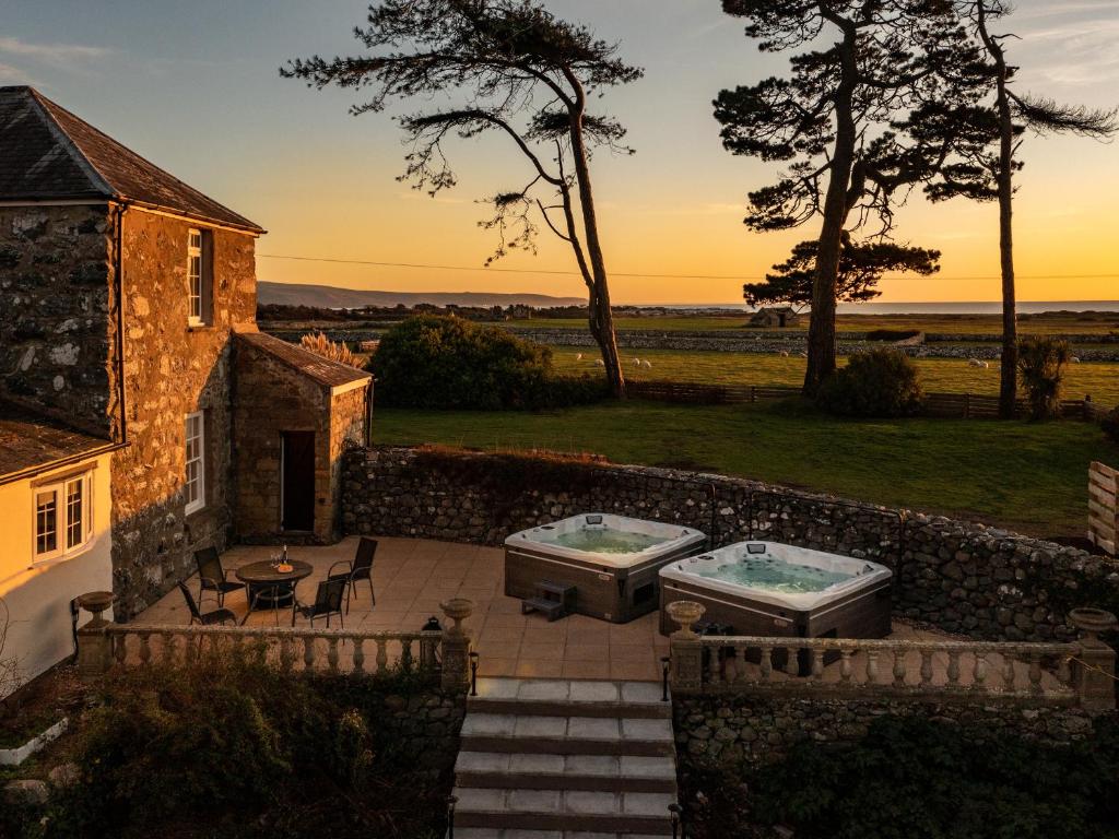 a house with two hot tubs on a patio at Bennar Fawr in Dyffryn